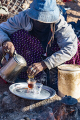 Fototapeta na wymiar Bedouin woman cooking tea on the fire in Bedouin village, Egypt