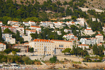 Fototapeta na wymiar Modern buildings and villas on the sea coast, on mountain background. Dubrovnik city, Croatia.