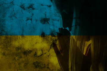 Stop the war in Ukraine. hands prays against the background of the flag of Ukraine, War in Ukraine,...