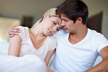 Fototapeta premium The best kind of comfort zone. Shot of a sad young woman being comforted by her husband in bed.