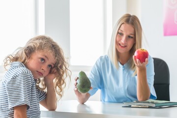 Beautiful nurse holds apple and avocado, healthy diet plan concept