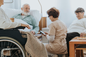 Helpful nurse switching on a professional bed in a nursing home
