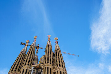 bottom view of the Sagrada Familia Cathedral over a blue sky background