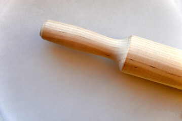 Wooden rolling pin for dough on a white background