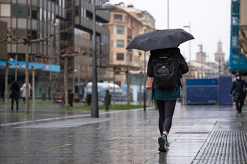Young woman in casual clothes shopping in the city on a rainy day