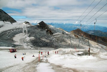 Hintertuxer Gletscher mit Skipiste Skifahrern Gipfelstation Seilbahn Pistenbully und gefrorene Wand