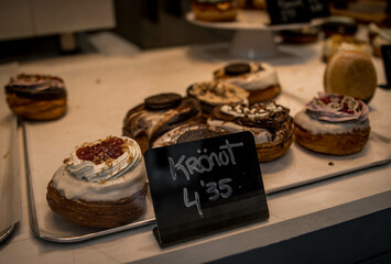 Yummy Sweet Chocolate Kronuts and Puff Pastry Donuts Type in a Shop Glass Window