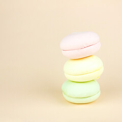 Sweet and colourful marshmallows looks like french macaroons on pastel cream background. Brignt macarons for sweet break