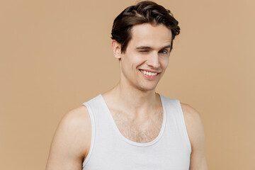 Attractive sexy handsome happy young man 20s perfect skin in undershirt wink look camera isolated...