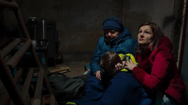 A scared family two women and a child hiding from danger in the cellar