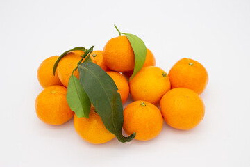 Few ripe tangerines with green leaves