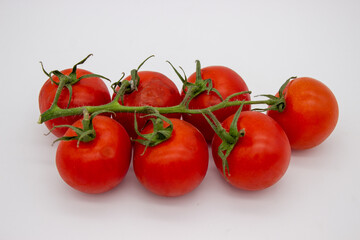 Cherry tomatoes on branch stand on white background