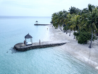 Beach of a Maldivian atoll with crystal clear sea.
