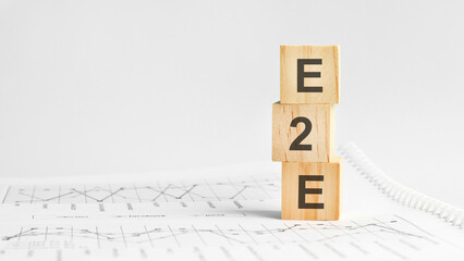 e2e - letters on wooden cubes. concept on cubes and diagrams on a gray background. business as...