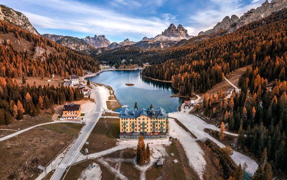 Misurina, Auronzo, Italy - Aerial view of Lake Misurina in the Italian Dolomites on an autumn morning with Tre Cime di Lavaredo peaks (Three Merlons), autumn foliage and blue morning sky and clouds