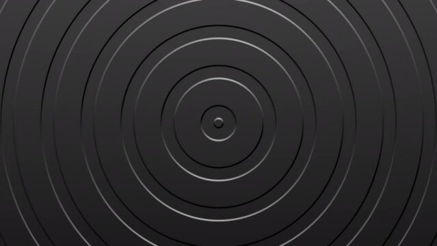 Abstract animated dark gray background. Indented circles moving outwards. 4k ready to loop