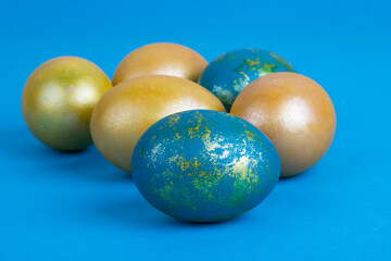 Golden Easter eggs on a blue background. Easter background