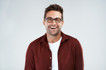 Funny and smart. Portrait of a cheerful young man wearing glasses and smiling brightly while...