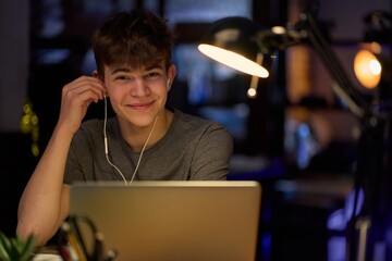 Teenage student learning at home with books and laptop computer. Online school and digital...