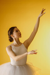 a girl dancer in a dancing pose on a yellow background © artem