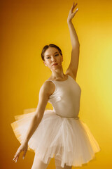 a girl dancer in a dancing pose on a yellow background © artem