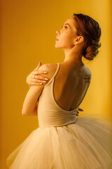 a girl dancer in a dancing pose on a yellow background © artem