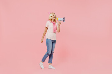 Full body elderly happy woman 50s in t-shirt birthday hat hold scream in megaphone announces discounts sale Hurry up isolated on plain pastel pink background studio Celebrating party holiday concept