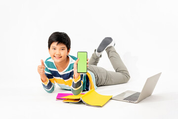Portrait of Happy asian boy holding a phone in his hands with a green screen on floor with with laptop and books isolated on white background with copy space, Education and learning with technology