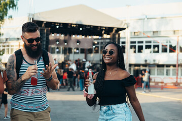 Beautiful couple drinking cocktails and having fun at music festival