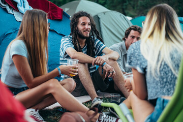 Friends having fun in their campsite at a music festival