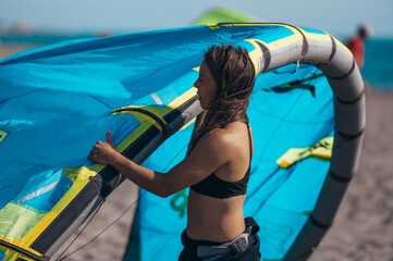 Woman preparing her kite for kitesurfing