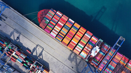 Aerial drone ultra wide top down photo of anchored container ship in loading - unloading in...