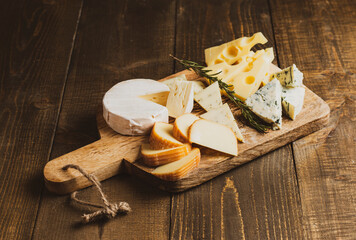 Different sorts of cheese on wooden background