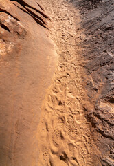 View of Narrow Path between Large Rocks with Shoe Prints on the Sand