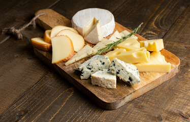Different sorts of cheese on wooden background