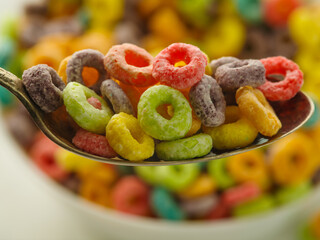 Macro shot. In a white bowl and spoon crunchy cereal fruit rings on a white background. Quick whole grain breakfasts, organic food. Shop, supermarket, sales, advertising business, banner.