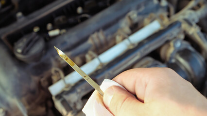 checking the oil level in a car engine