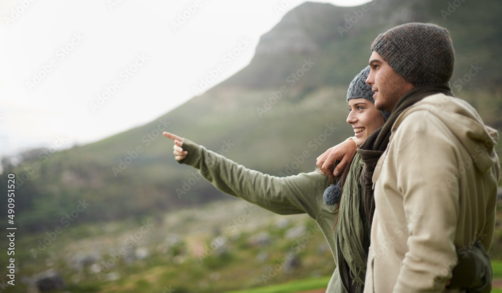 Sticker This view is stunning. A young couple admiring the view while out hiking during winter.