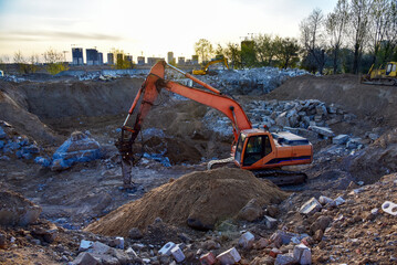 Excavator with hydraulic breaker hammer on destruction of concrete and hard rock at the...