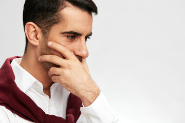 handsome businessman in a white shirt sweater on the shoulders pensive look light background