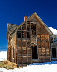 Abandon farmhouse in Fairfield Idaho with a spring bed hanging out of a window