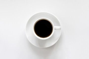White cup of coffee on a saucer, on a white background, top view