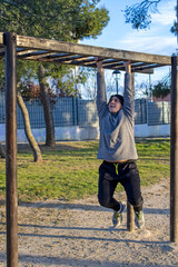 Teenage doing exercise in a park with parallel bars