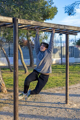 Teenage doing exercise in a park with parallel bars