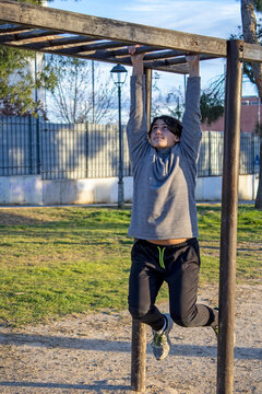 Teenage doing exercise in a park with parallel bars