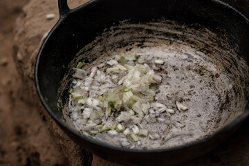 frying onion in a pot on the mountain