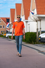 Dutchman celebrating kings day on the road during a street party dressed in orange in Holland the Netherlands. Koningsdag is a traditional festival to celebrate the Dutch royal family. Dutch flag.
