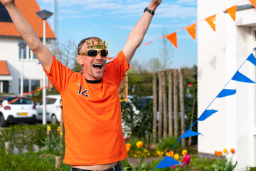 Dutchman celebrating kings day on the road during a street party dressed in orange in Holland the Netherlands. Koningsdag is a traditional festival to celebrate the Dutch royal family. Dutch flag.