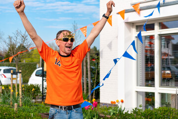 Dutchman celebrating kings day on the road during a street party dressed in orange in Holland the Netherlands. Koningsdag is a traditional festival to celebrate the Dutch royal family. Dutch flag.