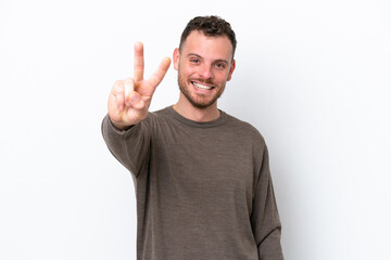 Fototapeta premium Young Brazilian man isolated on white background smiling and showing victory sign
